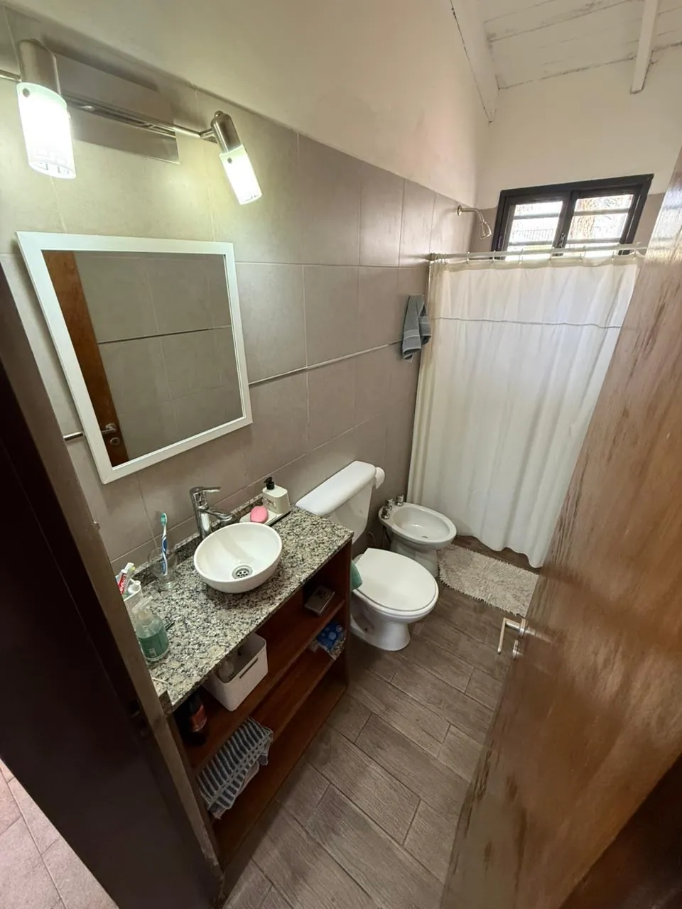 Baño completo reformado, con mesada de granito y bacha de apoyo