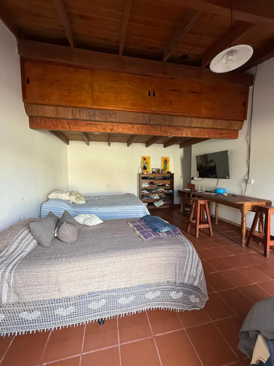 El dormitorio del quincho, de amplias dimensiones, con placard alto y lugar para escritorio