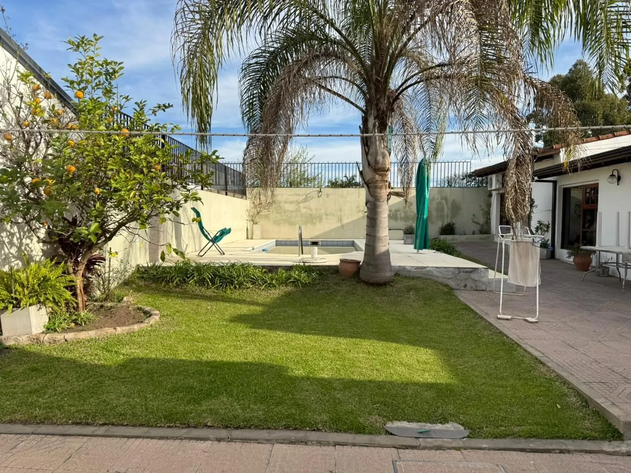 Parque con césped, palmeras y frutales