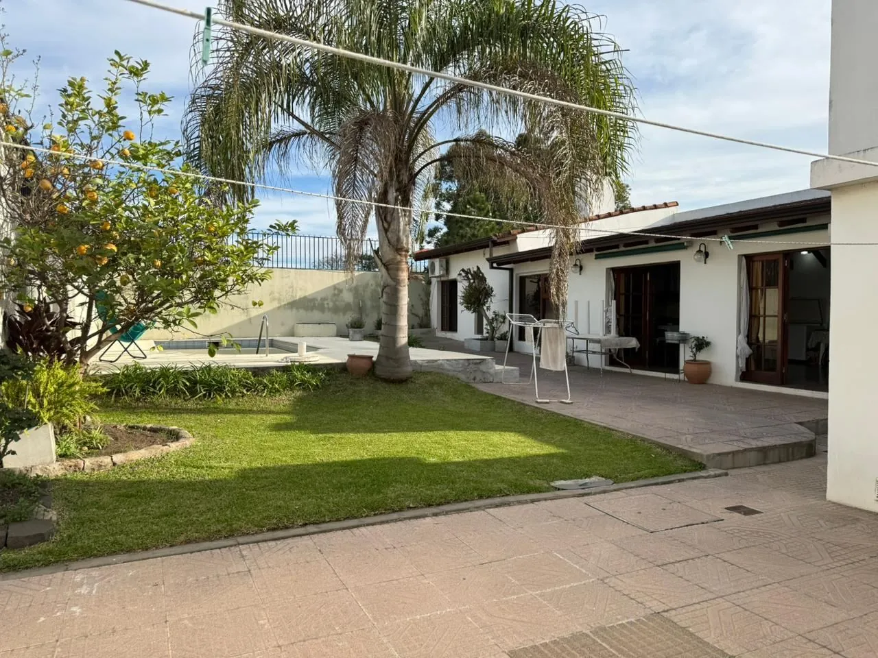 El patio que une la casa, el quincho y la pileta