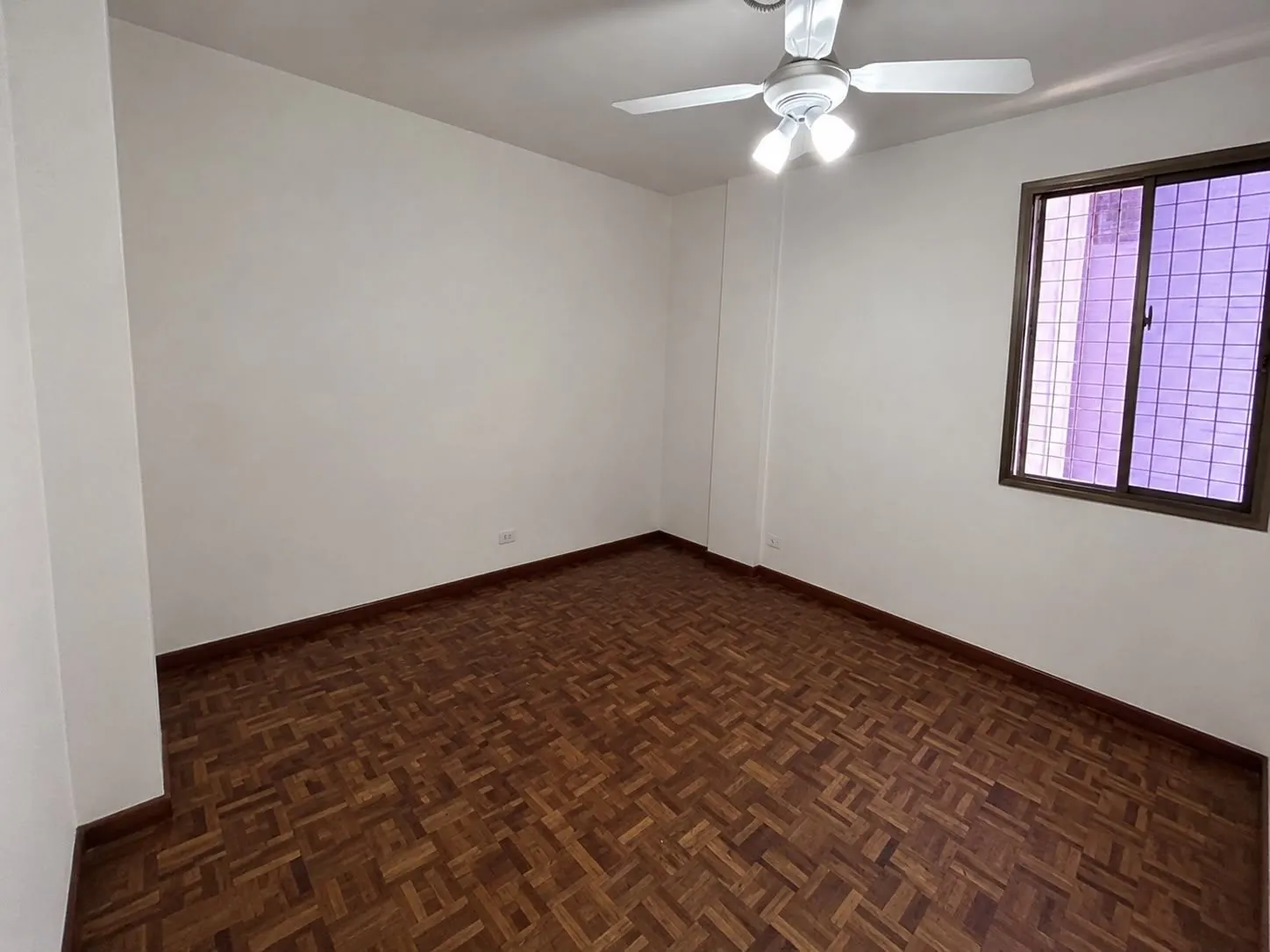 Dormitorio con parquet y ventilador de techo